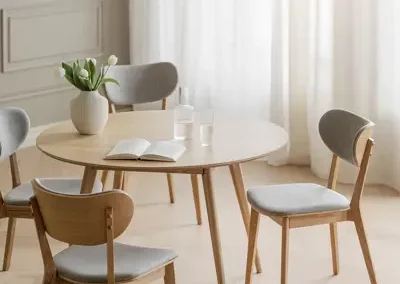 Rowico Filippa runt matbord i ek med stolar i matchande färg och grå stolsdyna i en minimalistiskt matsal